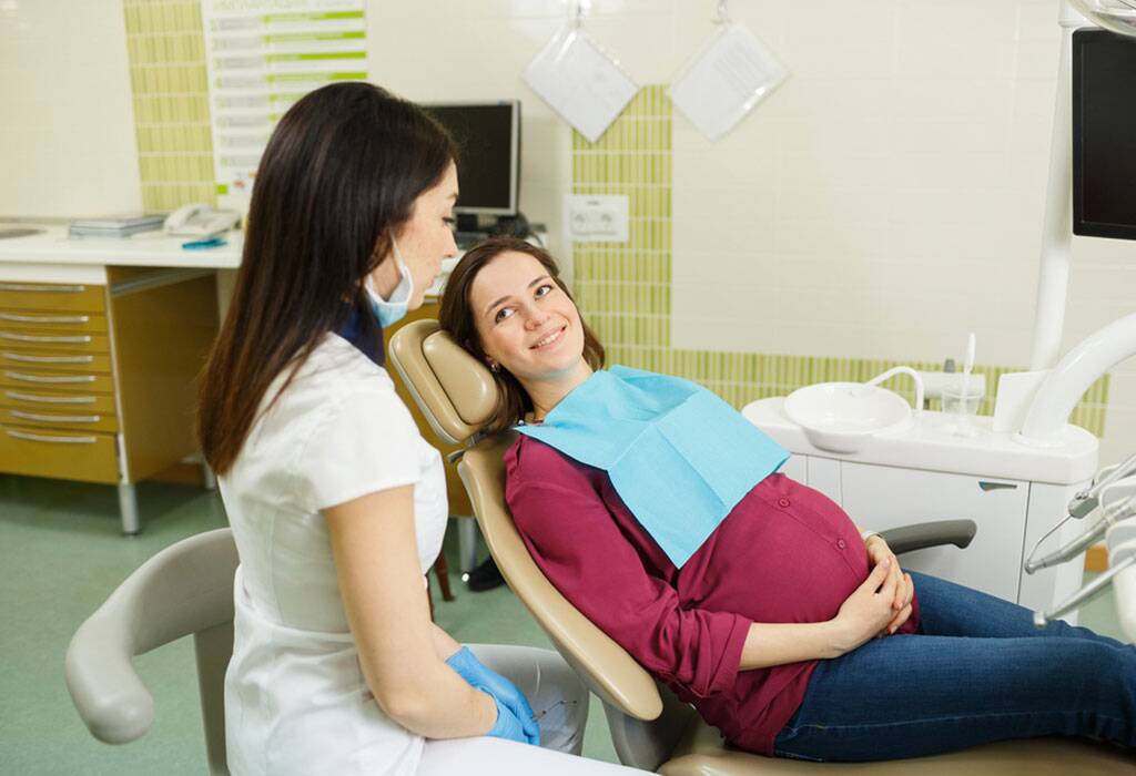 خانم بارداری که روی یونیت دندانپزشکی دراز کشیده و در انتظار کشیدن دندان در زمان بارداری است.