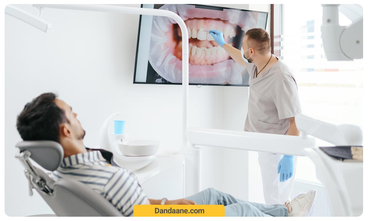متخصص ارتودنسی در حال بررسی عکس دندان های بیمارش