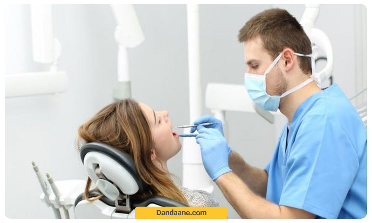 دندانپزشک در حال معاینه دندان