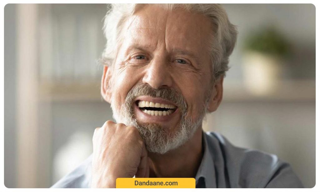 عکس یک مرد در حالی که دندان مصنوعی در دهان دارد می خندد